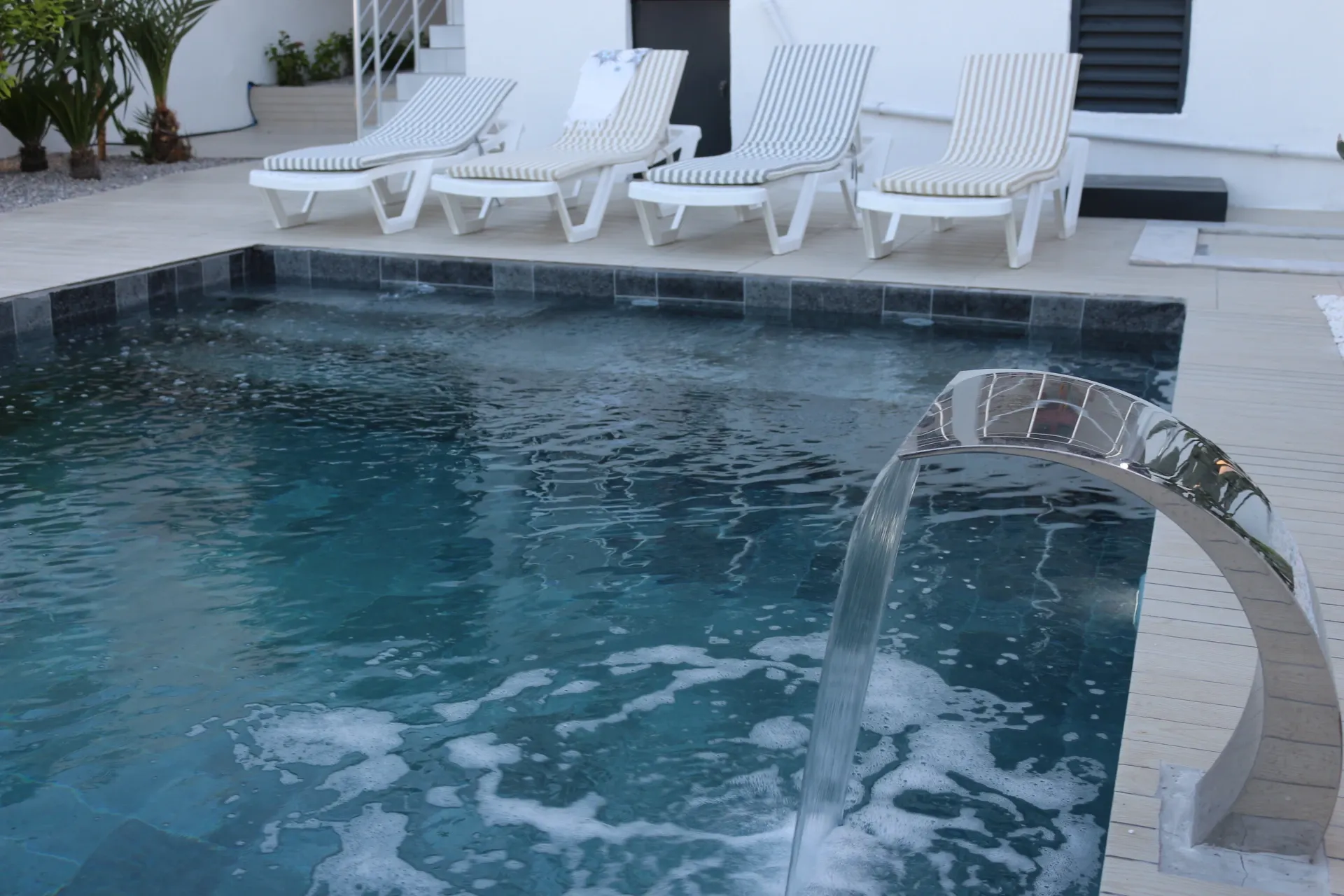 Stunning pool waterfall feature surrounded by Mediterranean garden